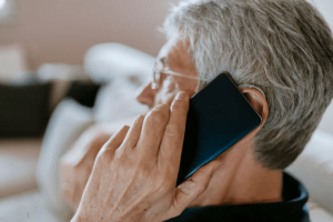old person talking on the phone while wearing hearing aid