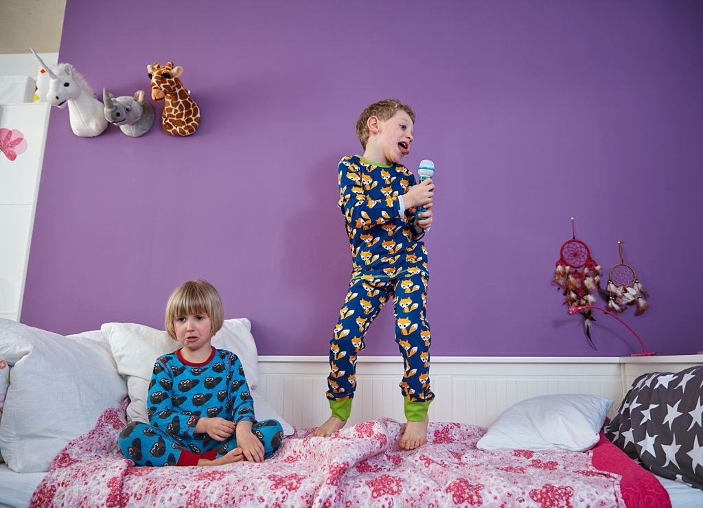 Brother and sister wearing pajamas in children's room