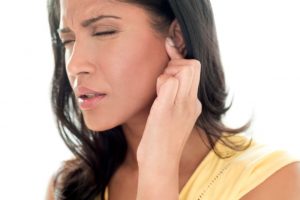 Woman touching ear in pain.