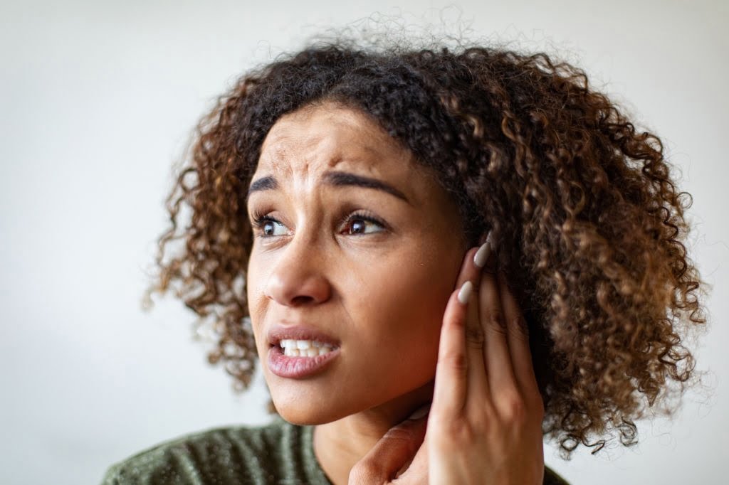 Biracial young woman with an ear ache